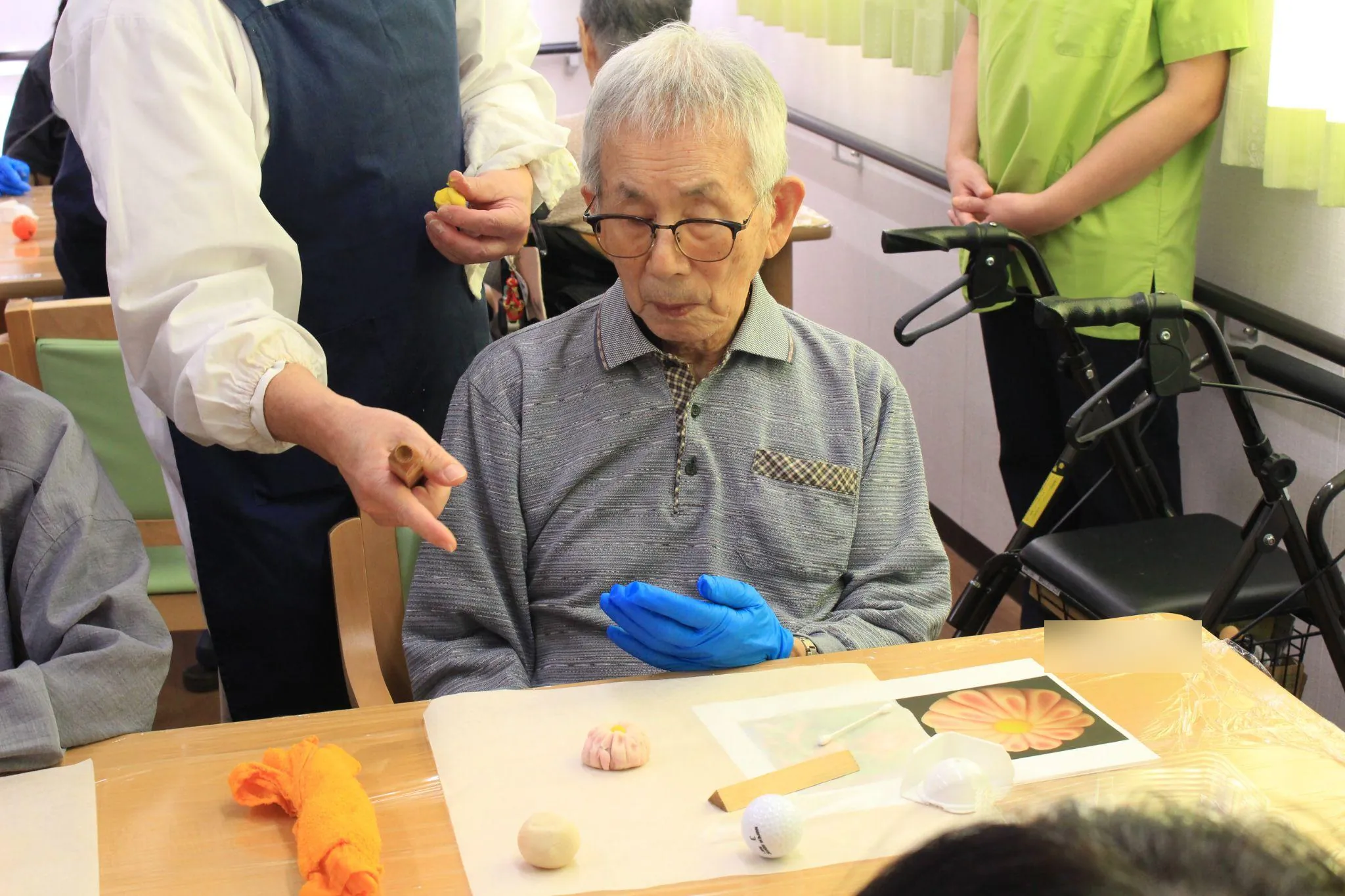 花芯の付いた菊の練り切りを、ご入居者さまが手元で見つめている