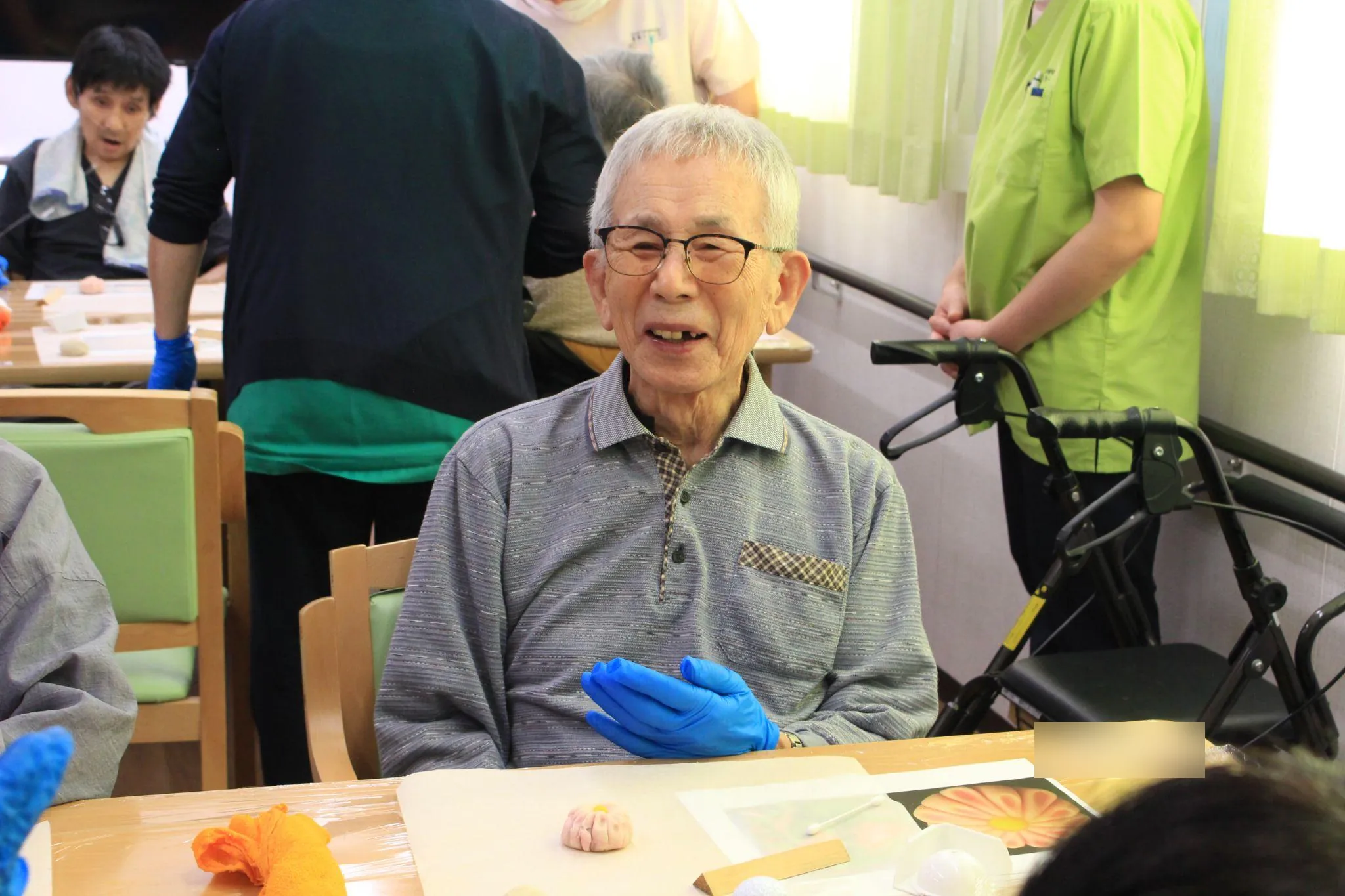 完成した菊の練り切りを前に、満面の笑みを浮かべるご入居者さま